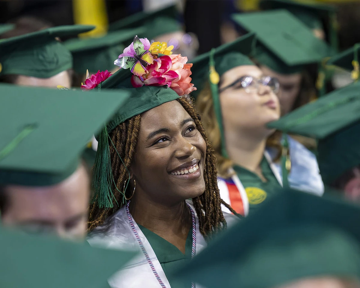 GMU graduate smiles in their cap and gown